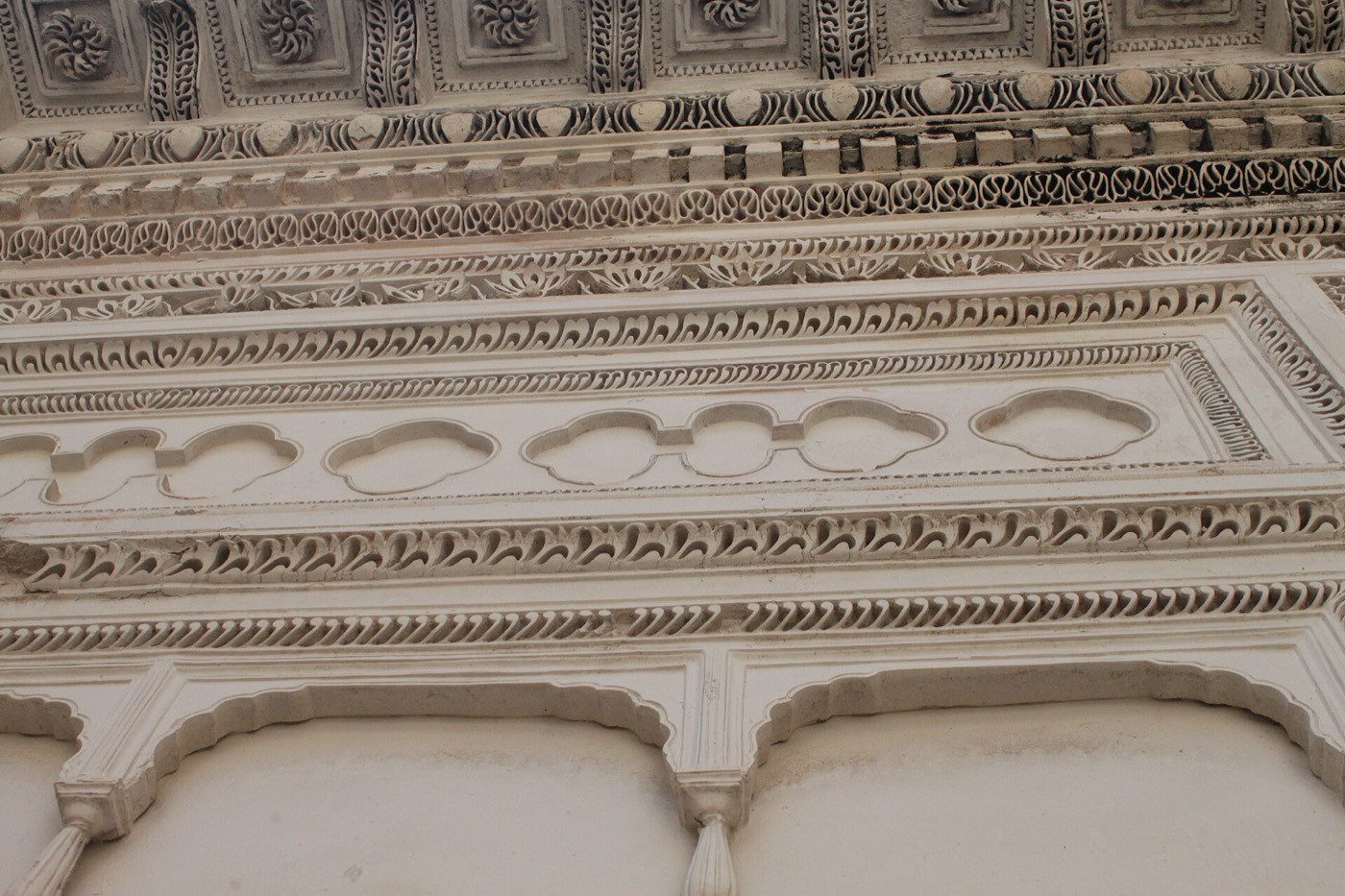 Carved stone detail of Indo-Islamic architecture with scalloped arches